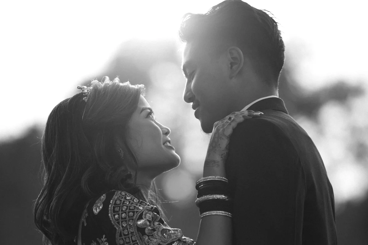 Black-and-white frame of a couple holding each other against the light