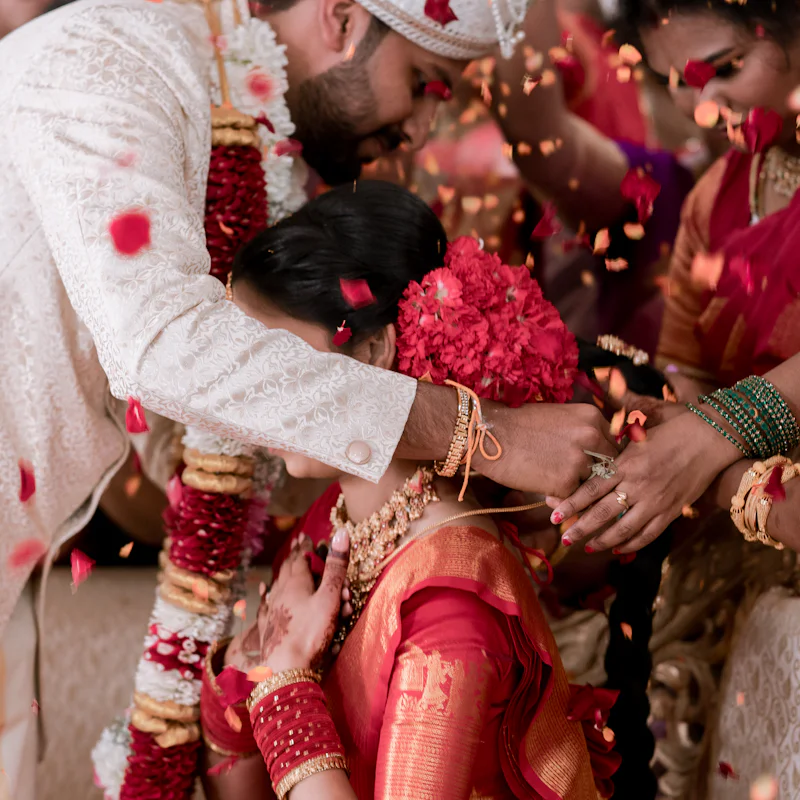 Rose petals falling as the varmala garlands are exchanged
